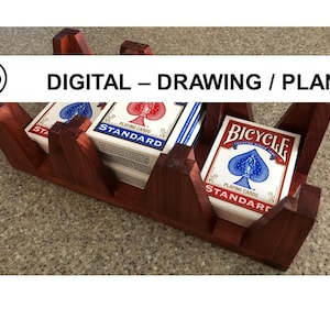 Könnte beinhalten: Ein Kartenhalter aus Holz mit drei Schlitzen zum Aufbewahren von Kartenspielen. Der Halter ist aus dunklem Holz und hat eine natürliche Oberfläche. Der Kartenhalter hält zwei Kartenspiele, eines mit einem roten und blauen Design und das andere mit einem blauen und weißen Design. Der Text "DIGITAL - DRAWING / PLAN" wird über dem Kartenhalter angezeigt.