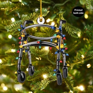 May include: A silver walker decorated with colorful Christmas lights. The walker is a Christmas ornament and is printed on both sides.