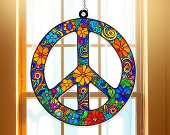May include: A colorful peace sign suncatcher with a floral design. The peace symbol is filled with flowers in shades of blue, orange, yellow, and red, with swirling patterns. It hangs from a black chain, perfect for a window or wall decoration.