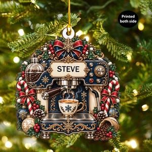 May include: A decorative Christmas ornament shaped like an espresso machine with the name STEVE printed on a central plaque. The design features red and blue accents, candy canes, holly, pinecones, and a coffee cup with a snowflake pattern.