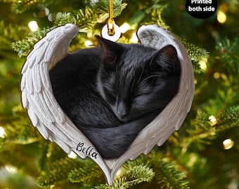 Può includere: Un ornamento a forma di gatto nero che dorme all'interno di ali d'angelo bianche. L'ornamento ha il nome "Bella" stampato sopra. L'ornamento è appeso a un filo d'oro ed è stampato su entrambi i lati.