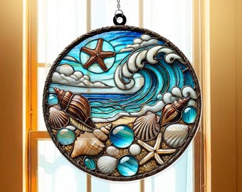 Puede incluir: Un atrapasol redondo de vidrio tintado con una ola azul, conchas marinas y una estrella de mar. El atrapasol está enmarcado en un marco de metal marrón y tiene una cadena para colgar.