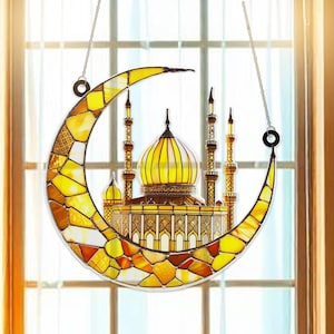 May include: A stained glass window hanging with a crescent moon and a mosque design. The mosque is yellow and gold with intricate details. The crescent moon is yellow and orange with a stained glass pattern.