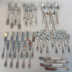 May include: A large collection of silver-toned flatware including various forks, spoons, and knives. The set features multiple dinner forks, salad forks, soup spoons, teaspoons, butter knives, and dinner knives, all with a polished metallic finish.