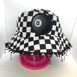 May include: A white ceramic mug with a black handle and the text "But First, Coffee" in a bold, black font. The mug is set against a blurred background, suggesting a cozy setting.