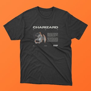 Puede incluir: Una camiseta negra con un gráfico de Charizard, un personaje de Pokemon. El gráfico es en blanco y negro e incluye el texto "CHARIZARD" en letras blancas. El texto "FIRE FIRE FIRE" está por encima del gráfico y el texto "#006" y "POISON" están por debajo del gráfico.