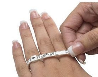 May include: White plastic ring sizer with numbered markings for measuring finger size.