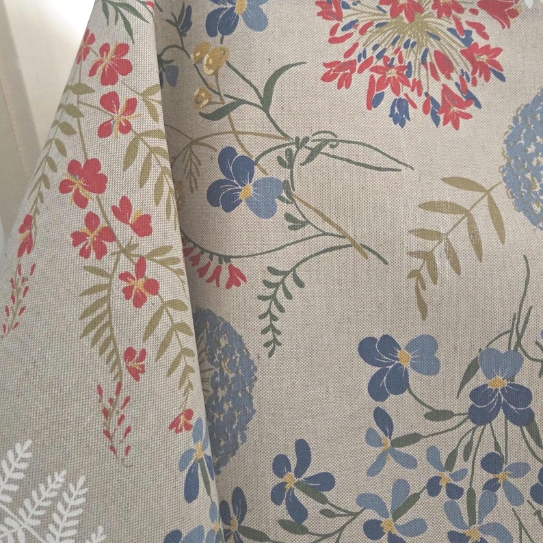 Table setting with wildflower Italian tablecloth, rustic French vintage style décor, dining room scene.