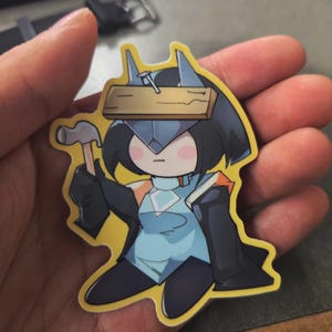 May include: A sticker featuring a cartoon character in a blue and black outfit, holding a hammer and a book. The character has a wooden plank with a nail on their head. The sticker has a yellow border.