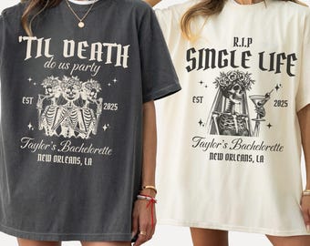 May include: Two oversized t-shirts in pepper grey and ivory. The pepper shirt features three skeletons and the text 'TIL DEATH do us party EST 2025 Taylor's Bachelorette NEW ORLEANS, LA. The ivory shirt shows a skeleton and 'R.I.P SINGLE LIFE'.
