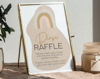 May include: A gold-framed sign with a pink, brown, and blue rainbow graphic. The sign says "Diaper Raffle" and includes instructions for participating in the raffle.