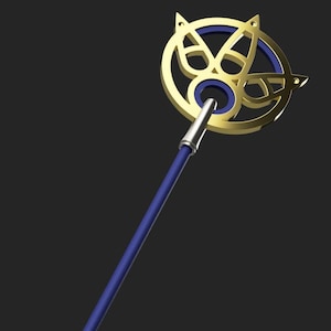 May include: A gold and blue decorative staff with a circular design at the top. The staff has a pink and blue handle.