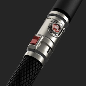 May include: A silver and black pen with a red button and a circular emblem with a red background and Chinese characters. The pen has a textured black grip.