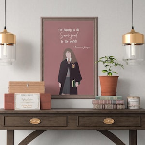 Puede incluir: Una impresión enmarcada con un fondo rosa que presenta una ilustración de dibujos animados de Hermione Granger de la serie Harry Potter. La cita "¡Espero hacer algo bueno en el mundo! - Hermione Granger" está impresa debajo de la ilustración.