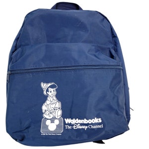 May include: A blue backpack with a white outline of a cartoon character, a Mickey Mouse head, and the text "Waldenbooks The Disney Channel".