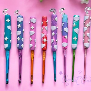 May include: A collection of ten crochet hooks with colorful handles. Each handle is decorated with white clouds, stars, and a silver crescent moon. The hooks are in various colors, including red, blue, purple, pink, and green. The hook sizes are 4.0mm, 4.5mm, and 5.0mm.