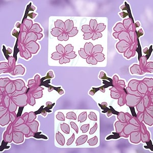 May include: A set of pink and white cherry blossom stickers. The stickers feature branches with pink flowers and green leaves, as well as individual pink flowers and petals.
