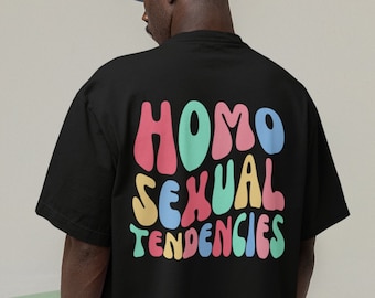 May include: Black t-shirt with a colorful graphic that says "HOMO SEXUAL TENDENCIES" in a retro font.