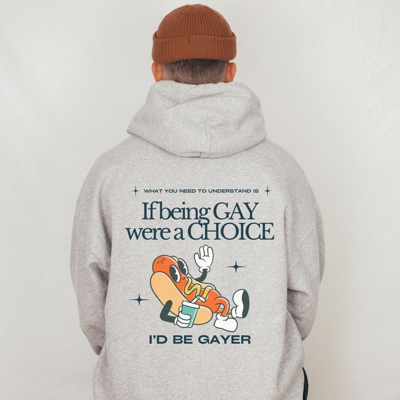 the words 'what you need to understand is if being gay were a choice i'd be gayer.' with a mascot sausage on the back of an ash colored hoodie