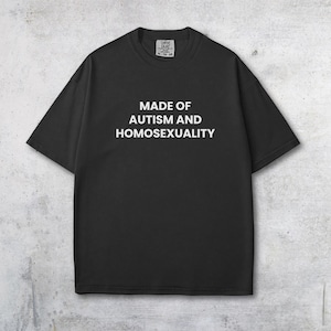Puede incluir: Camiseta negra con el texto blanco "MADE OF AUTISM AND HOMOSEXUALITY" centrado en la parte delantera. La camiseta tiene cuello redondo y mangas cortas. La tela parece suave y ligeramente texturizada.