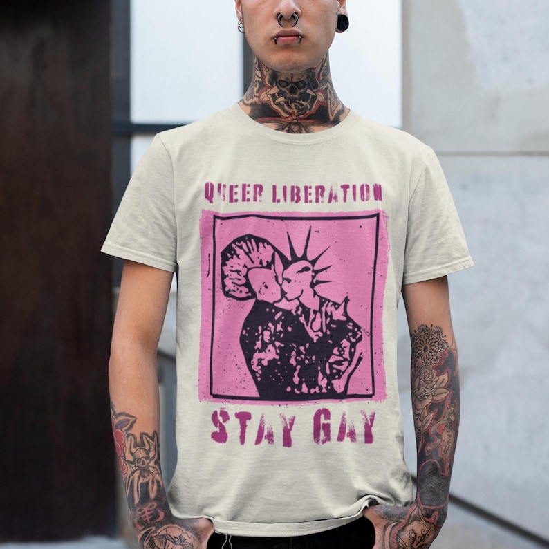 queer liberation stay gay with kissing punks on the front of an ivory comfort colors shirt