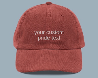May include: A red corduroy baseball cap with white embroidery that says "your custom pride text".