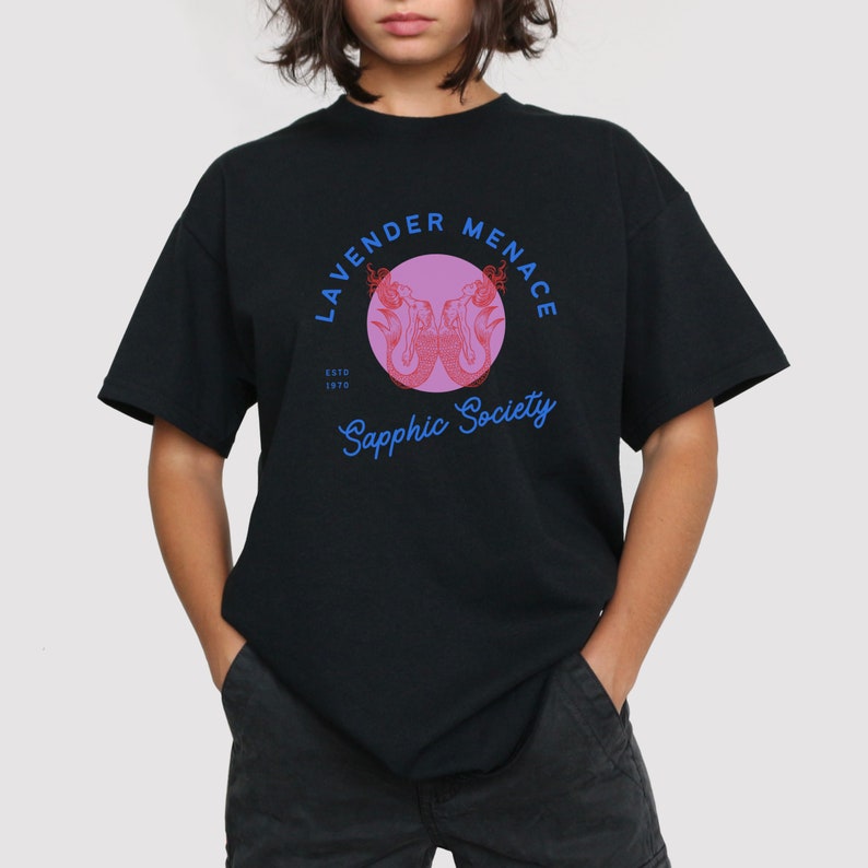 May include: Black t-shirt with a pink circle graphic featuring two mermaids and the text "Lavender Menace Sapphic Society EstD 1970"