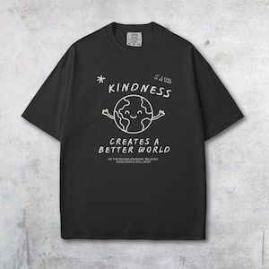 May include: Black t-shirt featuring a white graphic of a smiling globe with arms, the word "KINDNESS", and the phrase "CREATES A BETTER WORLD". The shirt also includes the text "BE THE REASON SOMEONE BELIEVES GOOD PEOPLE STILL EXIST".