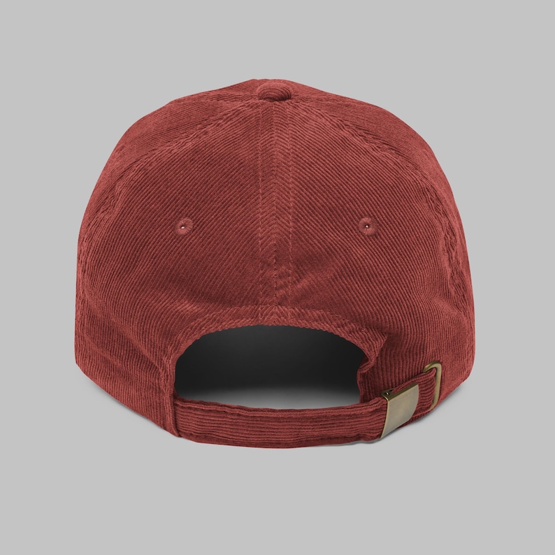 Puede incluir: Gorra de b&eacute;isbol de pana color ladrillo. La gorra presenta una visera curva, un dise&ntilde;o de seis paneles y una correa ajustable con una hebilla color lat&oacute;n. La parte trasera de la gorra tiene una peque&ntilde;a abertura para la ventilaci&oacute;n.