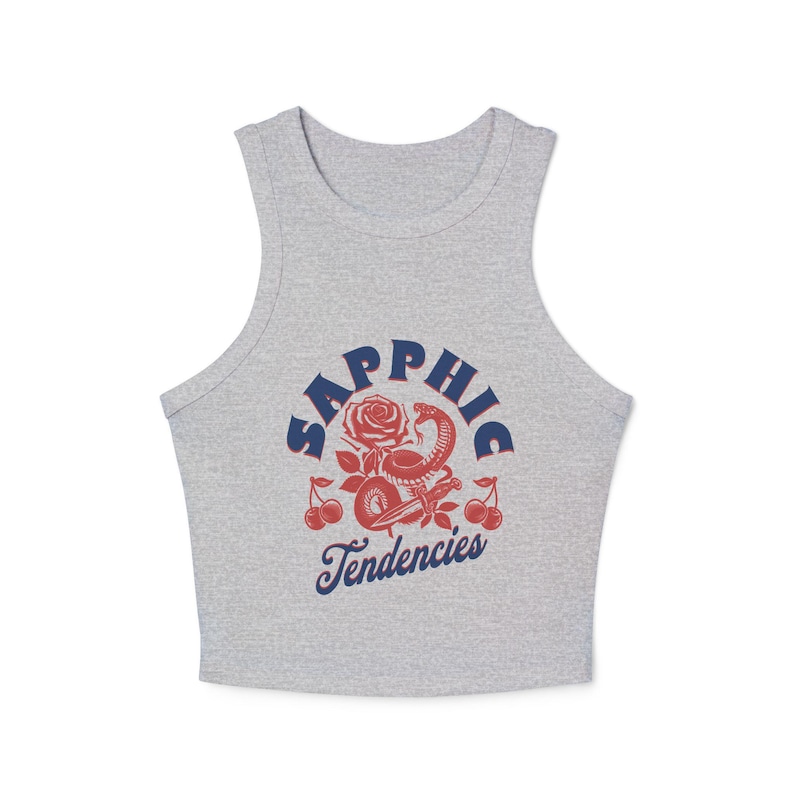 Puede incluir: Una camiseta sin mangas gris con un dise&ntilde;o gr&aacute;fico. El dise&ntilde;o presenta la palabra "Sapphic" en azul, una rosa roja, una serpiente roja y cerezas. Las palabras "Tendencies" est&aacute;n escritas en azul debajo.