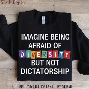 Op de afbeelding: Zwart sweatshirt met de tekst "IMAGINE BEING AFRAID OF DIVERSITY BUT NOT DICTATORSHIP" in het wit. Het woord "DIVERSITY" staat in kleurrijke blokletters. De merknaam "Sheila Degisn" staat linksboven.
