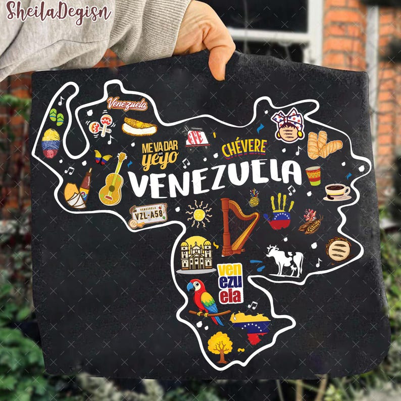 May include: Black tote bag featuring a white outline of Venezuela, filled with colorful illustrations of Venezuelan culture. Includes text that reads "Venezuela", "Me Va Dar Yeyo", and "Ch&eacute;vere".