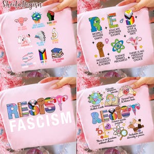 May include: Pink t-shirts with various graphic designs and text. One shirt says "RESIST FASCISM" in rainbow colors. Other shirts feature phrases like "Respect Mother Earth," "Spread Love & Silence Hate," and "Inclusion & Diversity is Power."