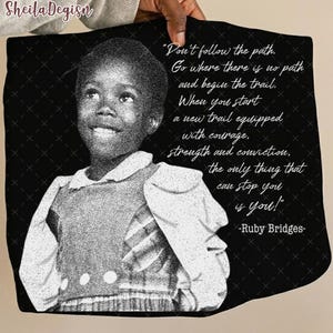 Op de afbeelding: Zwart-wit afbeelding van Ruby Bridges met een citaat: "Volg het pad niet. Ga waar er geen pad is en begin de tocht. Als je een nieuw pad begint, uitgerust met moed, kracht en overtuiging, is het enige dat je kan stoppen, jij!" -Ruby Bridges-