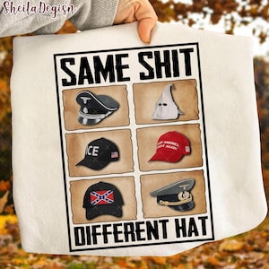 May include: White towel with the text "SAME SHIT DIFFERENT HAT" in black. The design features six images of different hats, including a Nazi hat, a KKK hood, and a "Make America Great Again" hat.