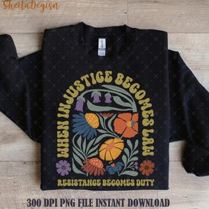 Könnte beinhalten: Schwarzer Pullover mit einem gelben und grünen Blumendesign und dem Text "Wenn Ungerechtigkeit zum Gesetz wird, wird Widerstand zur Pflicht".