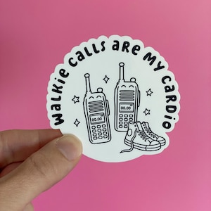 May include: A circular white sticker with a black line art illustration of two walkie-talkies and a pair of high-top sneakers. The text "walkie calls are my cardio" is printed in black along the curved top edge, accented by small star icons.