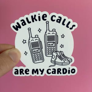 May include: A white die-cut sticker featuring black line art of two walkie-talkies and a pair of high-top sneakers. The text "WALKIE CALLS ARE MY CARDIO" is printed in a bold, rounded black font, accented by small star shapes surrounding the items.
