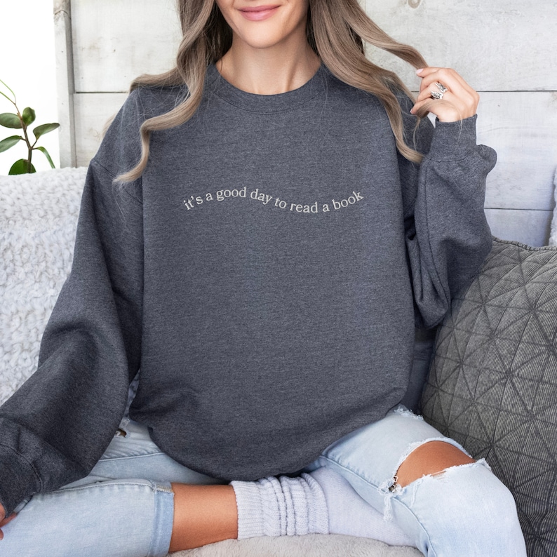 May include: A dark gray sweatshirt with the text "it's a good day to read a book" in white.