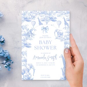 Puede incluir: Invitaci&oacute;n a un baby shower con un tema de safari azul y blanco. La invitaci&oacute;n presenta jirafas, elefantes y globos aerost&aacute;ticos. El texto incluye "Baby Shower" y el nombre "Amanda Smith".