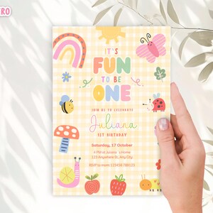 May include: A colorful birthday invitation with the text "IT'S FUN TO BE ONE" and the name "Juliana". The invitation features illustrations of a rainbow, butterfly, bee, ladybug, mushroom, snail, apple, and caterpillar on a yellow gingham background.