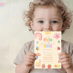 May include: A colorful birthday invitation with the text "IT'S FUN TO BE ONE" held by a child. The invitation features a rainbow, sun, butterfly, bee, mushroom, and other cute illustrations. The background is a yellow gingham pattern.