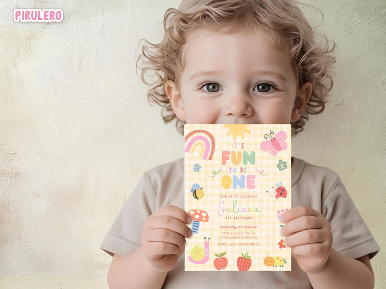 May include: A colorful birthday invitation with the text "IT'S FUN TO BE ONE" held by a child. The invitation features a rainbow, sun, butterfly, bee, mushroom, and other cute illustrations. The background is a yellow gingham pattern.