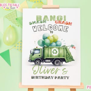 May include: A green and white welcome sign for a birthday party featuring a green refuse truck and balloons. The sign reads "Bang! Smash Crash Welcome to Oliver's Birthday Party".