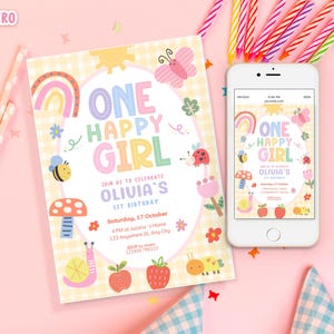 May include: A colorful birthday invitation and a smartphone displaying the same design. The invitation features the text "ONE HAPPY GIRL" with illustrations of a rainbow, butterfly, bee, and other whimsical elements. Candles are in the background.