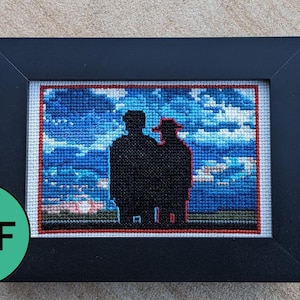 Puede incluir: Obra de arte de punto de cruz en un marco negro. La imagen muestra dos figuras silueteadas contra un cielo azul con nubes blancas. La palabra "PDF" está en un círculo verde en la esquina inferior izquierda.