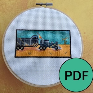 May include: Cross stitch pattern of a gray truck driving through a desert landscape. The pattern is in a white embroidery hoop with a green PDF label.
