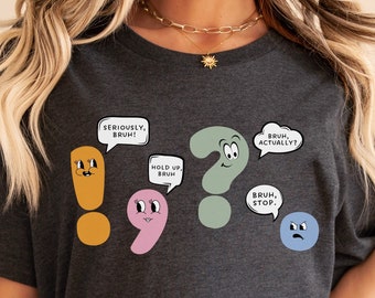 May include: Dark grey heather t-shirt with a cartoon exclamation point, question mark, and comma with speech bubbles that say "Seriously, bruh!" "Hold up, bruh" "Bruh, actually?" and "Bruh, stop."