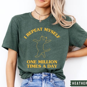 May include: A green t-shirt with a yellow graphic of a cat and the text "I repeat myself one million times a day".