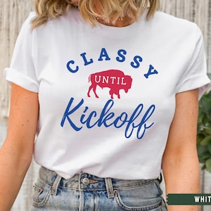 May include: White t-shirt with blue text that says "Classy Until Kickoff" and a red and blue buffalo silhouette.